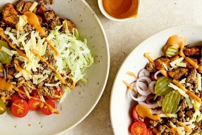 Burger bowl with seasoned ground beef, lettuce, pickles, tomatoes, cheddar, and special burger sauce