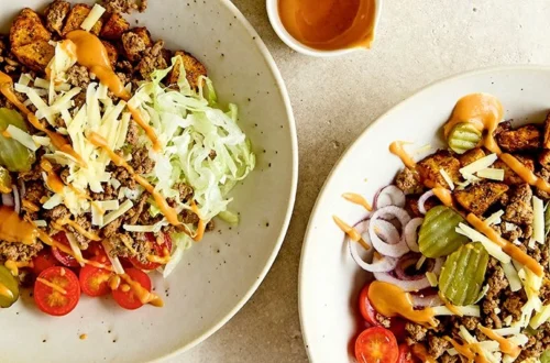Burger bowl with seasoned ground beef, lettuce, pickles, tomatoes, cheddar, and special burger sauce