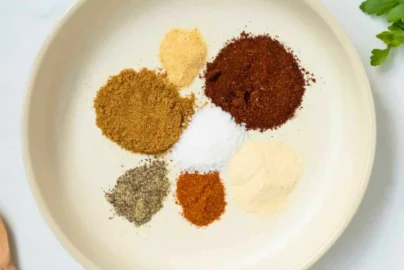 measured spices for chili seasoning in a bowl including chili powder, cumin, paprika, garlic powder, onion powder, salt and pepper