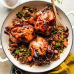 roasted Cornish hens with glossy browned skin in a large skillet with stuffing and green onions