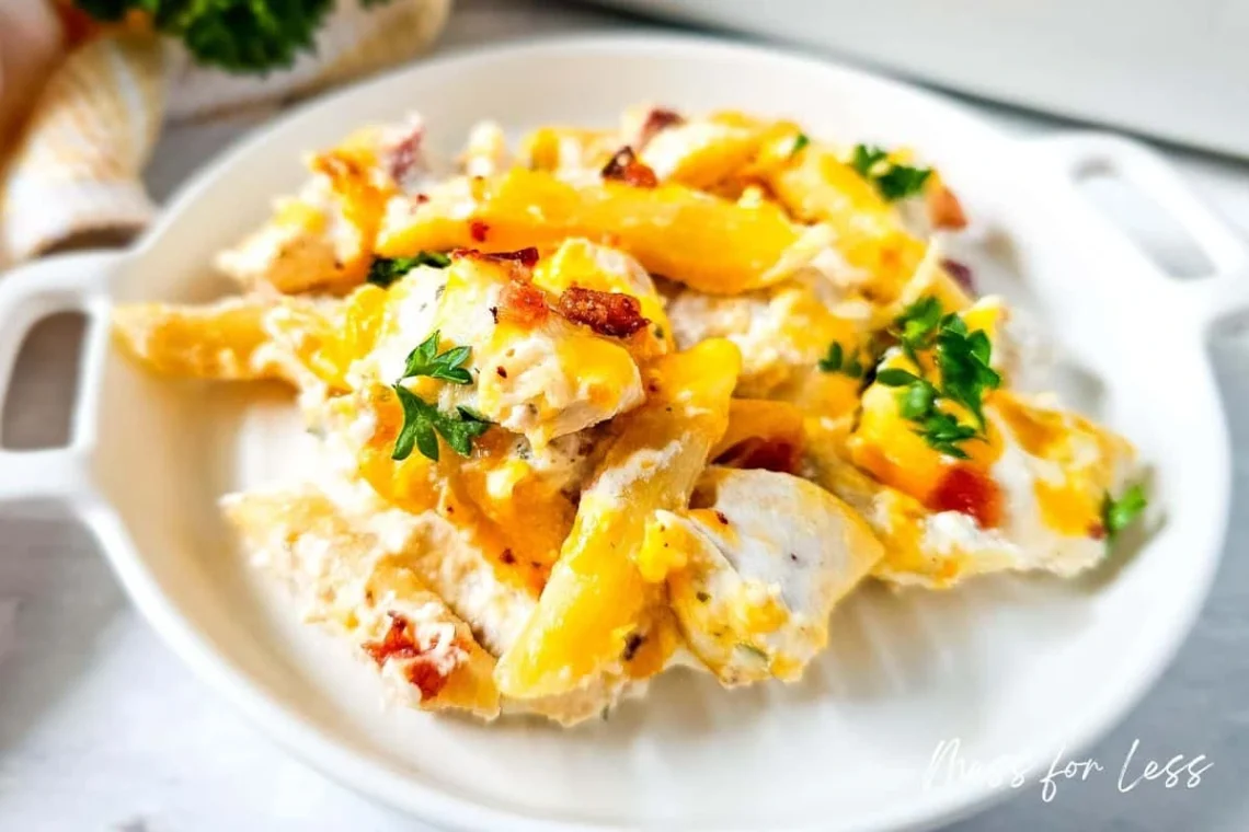 creamy crack chicken with melted cheddar and bacon served in a white dish