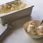 homemade vanilla ice cream in a loaf pan with scoops served in a bowl