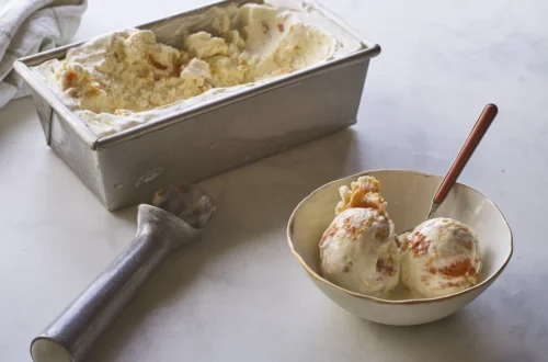 homemade vanilla ice cream in a loaf pan with scoops served in a bowl