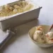 homemade vanilla ice cream in a loaf pan with scoops served in a bowl