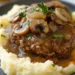 hamburger steak patty with mushroom onion gravy served over mashed potatoes