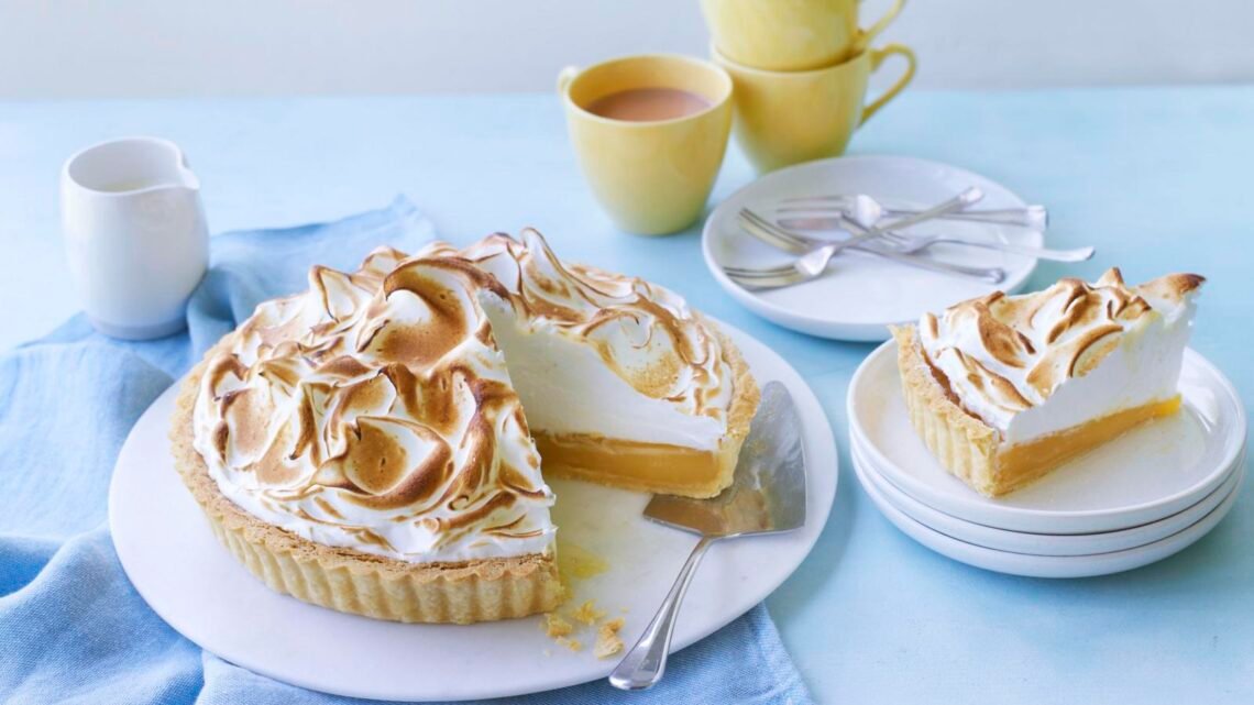 toasted meringue topped lemon pie with a slice served on a plate