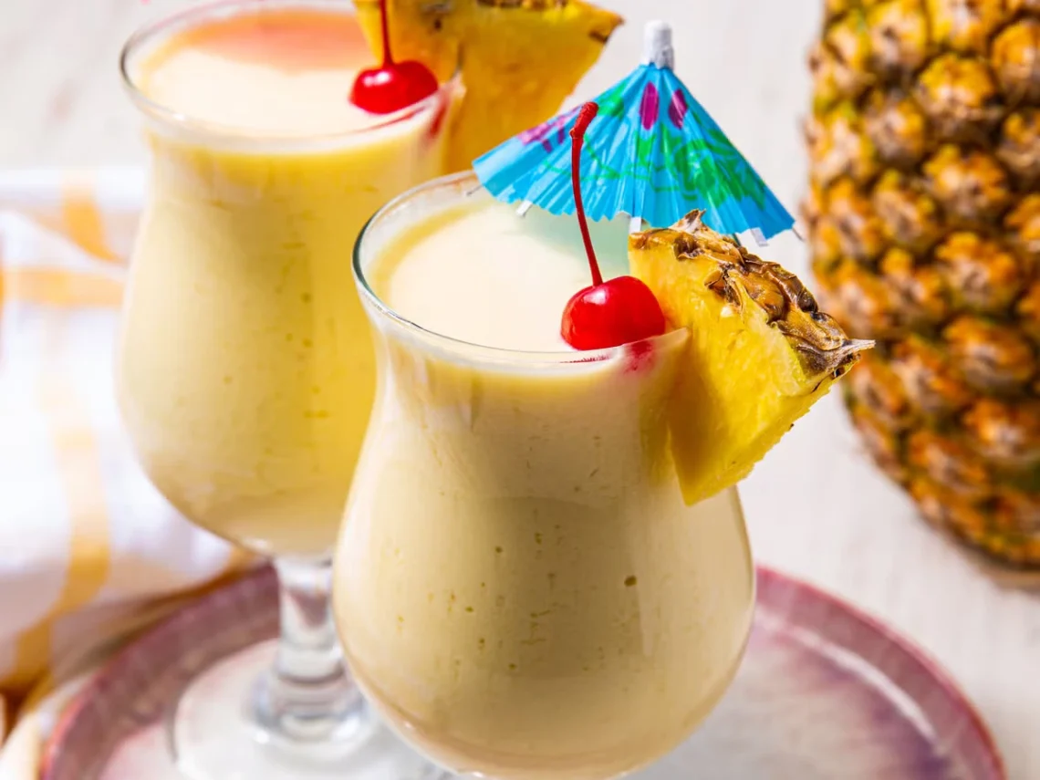 Virgin pina colada in tall glasses with pineapple garnish and creamy frozen texture