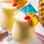 Virgin pina colada in tall glasses with pineapple garnish and creamy frozen texture