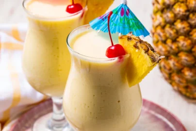 Virgin pina colada in tall glasses with pineapple garnish and creamy frozen texture