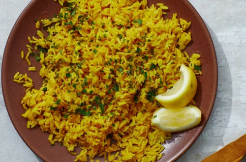 fluffy yellow rice in a bowl garnished with herbs, served as a golden side dish