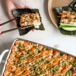 sushi bake casserole with spicy mayo drizzle served with nori sheets, cucumber and green onion