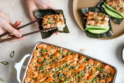 sushi bake casserole with spicy mayo drizzle served with nori sheets, cucumber and green onion