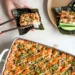 sushi bake casserole with spicy mayo drizzle served with nori sheets, cucumber and green onion